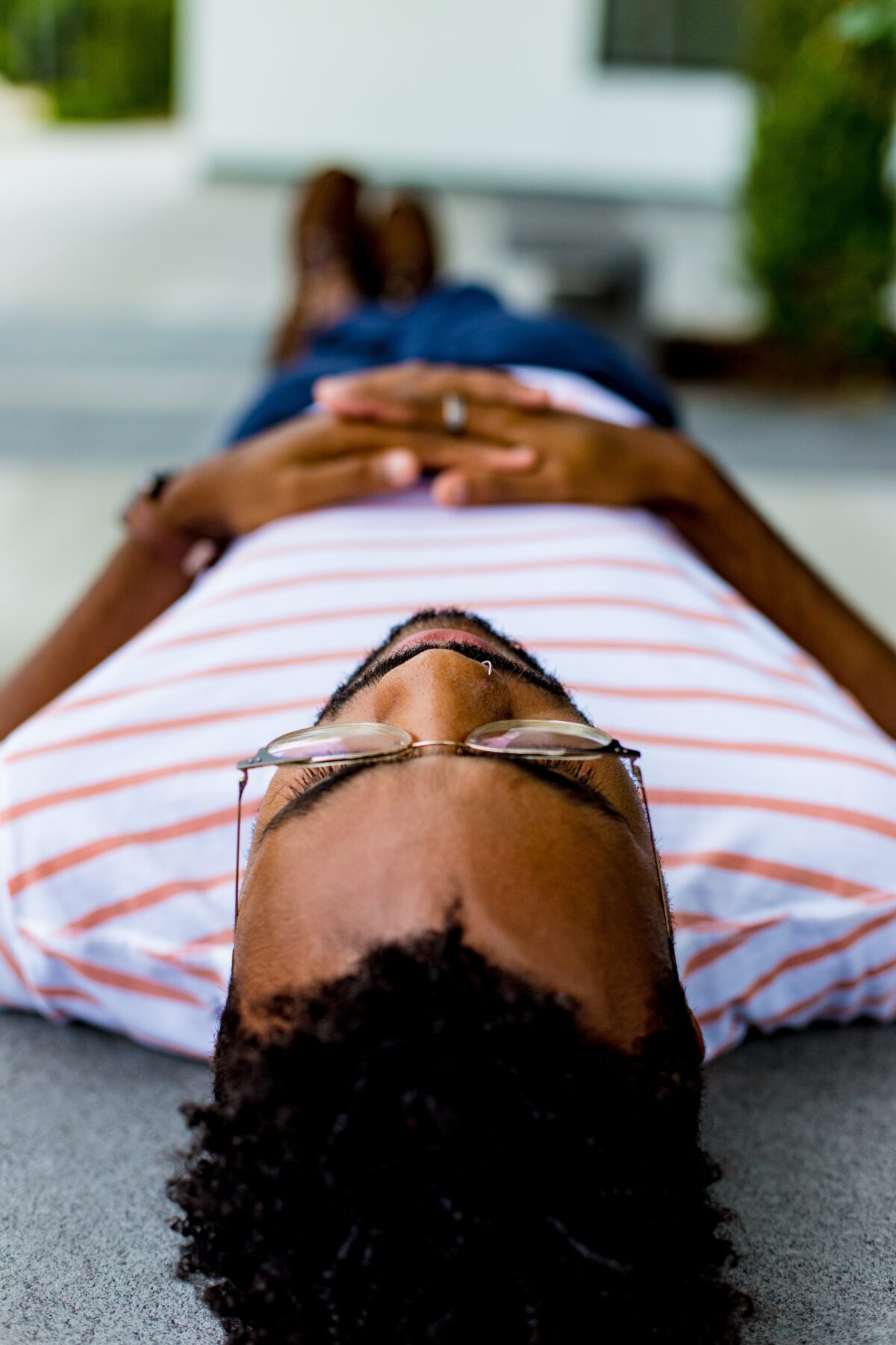 man wearing eyeglasses lying on concrete pavement